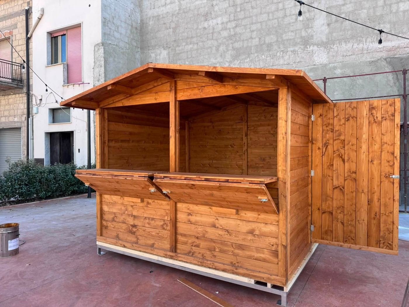 Chiosco in legno con bancone ribaltabile aperto e porta di servizio sul lato